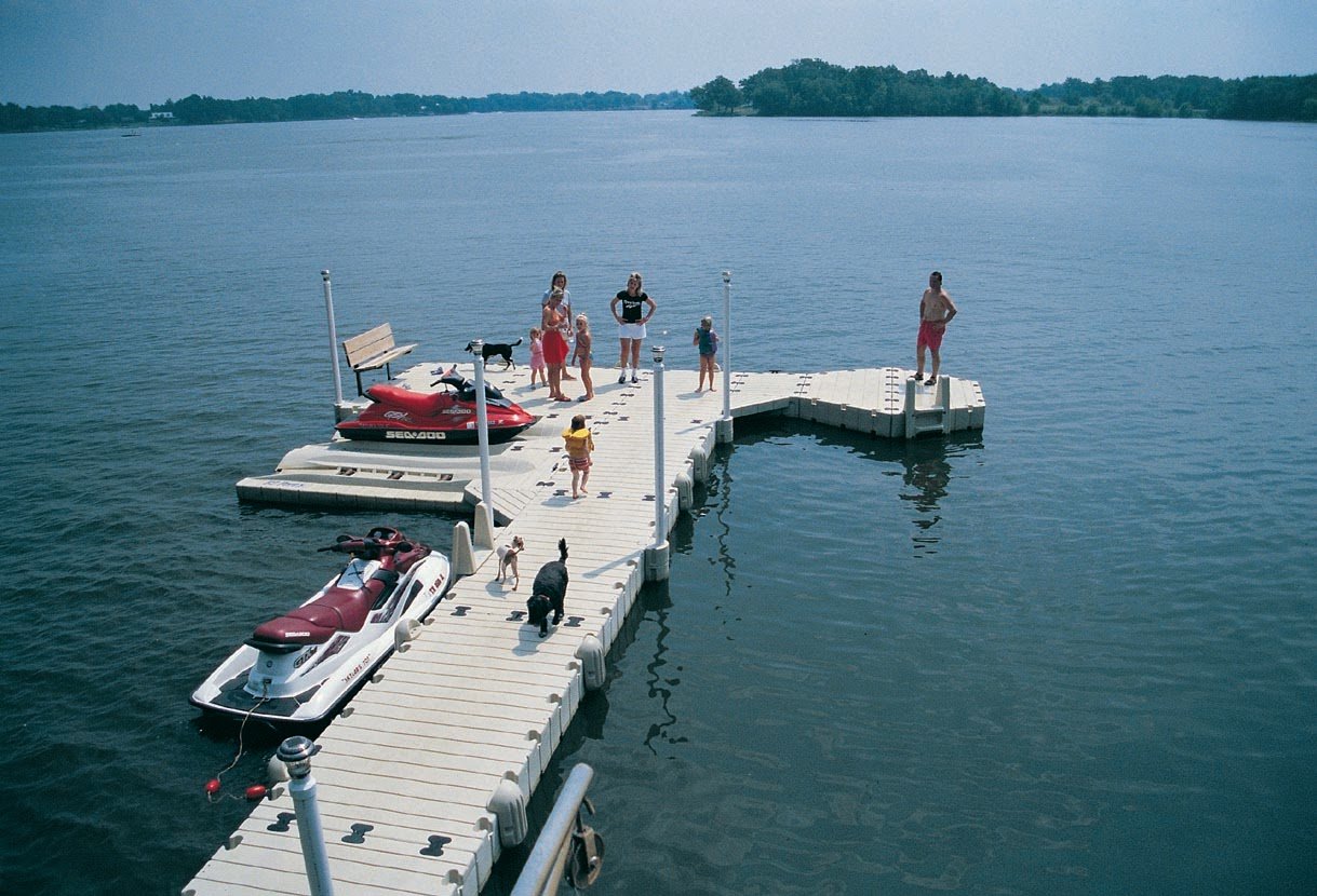 a family on a dock with dogs and jet skis