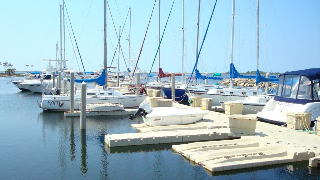sailboats docked to a white plastic dock
