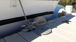 A boat tied up to a dock cleat using a cleat hitch.
