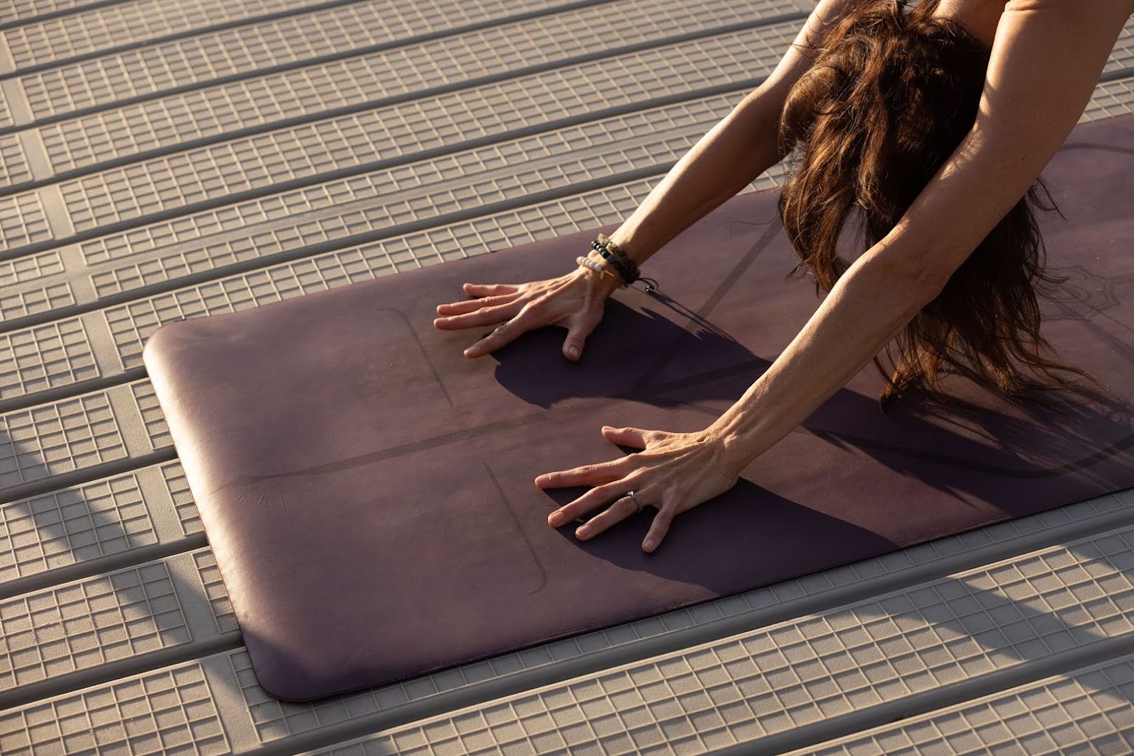 A-woman-does-a-yoga-pose-over-her-mat,-which-sits-on-a-floating,-plastic-dock.