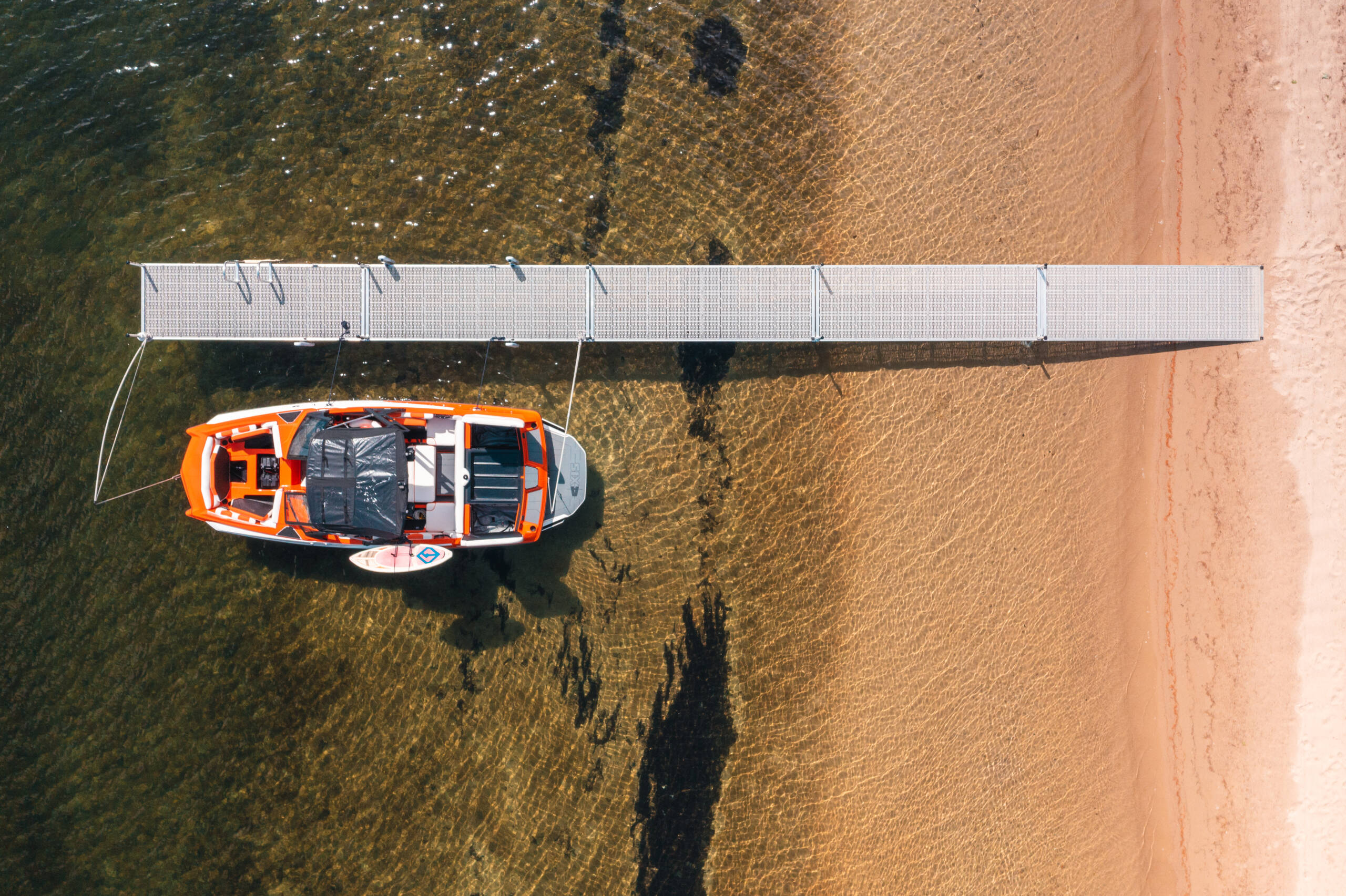 Rolling aluminum dock with boat tied at shore.