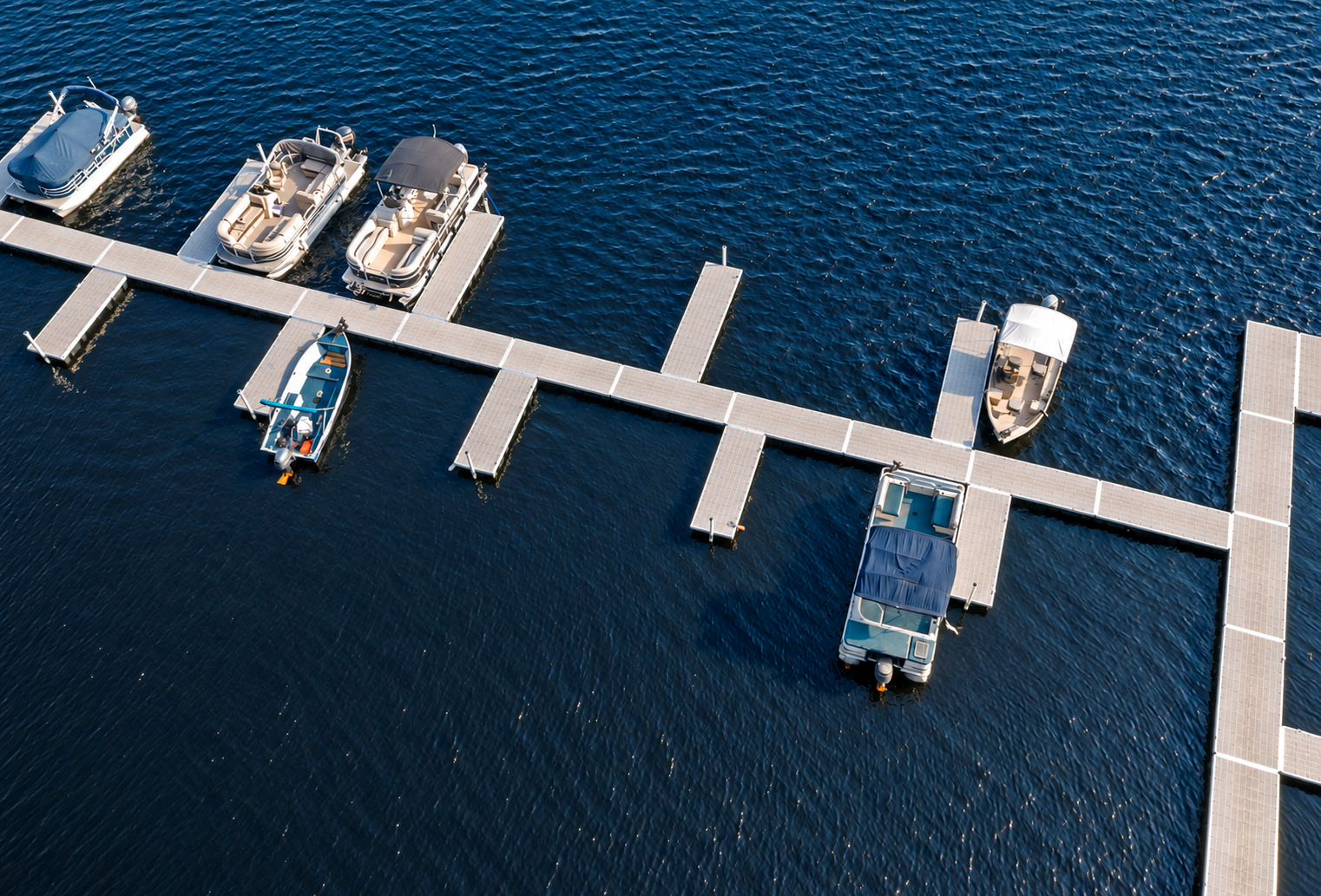 Aerial view of a marina dock layout with finger slips and moored boats